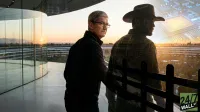 A composite image shows Apple CEO Tim Cook in a dark jacket and glasses looking over his shoulder, standing on a modern glass-walled balcony at sunset. To his right, a semi-transparent figure of a man in a cowboy hat faces the sunset, with a glowing circuit board design overlaid on his form and the sky. The background features the Apple Park campus architecture and a vibrant orange sunset.