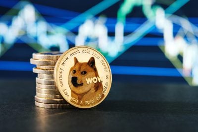 A close-up shot of a gold-colored Dogecoin coin, featuring the Shiba Inu dog meme and text like 'WOW much coin how money'. Behind it, a stack of similar gold-colored coins is visible. The background is a blurred display of blue and green light lines, resembling a financial chart with an upward trend.