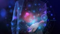 A person in a dark suit holds out their right hand, palms up. Overlaid on the scene is a glowing, complex holographic display featuring geometric shapes, lines, numbers, and symbols on a dark blue and purple background. A large, bright pink and purple glowing hexagon with the word 'SOLANA' at its base is centered above the hand, containing a triangular symbol. A glowing blue sphere rests in the palm of the hand. The overall impression is futuristic and technological.