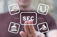 A person's hand reaches out to touch a glowing, central white square button labeled 'SEC'. Radiating from it are four other white outlined square icons: a magnifying glass with up and down arrows, a balance scale weighing Bitcoin and dollar symbols, a classical government building, and a judge's gavel. The background is a blurred image of a person and a warm-toned environment, suggesting a digital interface.