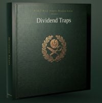 A dark green, hardbound book titled 'Dividend Traps' stands upright and slightly angled. The cover features the title in white text, 'A 24/7 WALL STREET READER GUIDE' at the top, and a gold emblem below it. The emblem depicts a broken coin, a quill, and a magnifying glass, encircled by a laurel wreath. The spine of the book also reads 'DIVIDEND TRAPS' in white text.