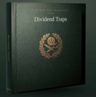 A dark green, hardbound book titled 'Dividend Traps' stands upright and slightly angled. The cover features the title in white text, 'A 24/7 WALL STREET READER GUIDE' at the top, and a gold emblem below it. The emblem depicts a broken coin, a quill, and a magnifying glass, encircled by a laurel wreath. The spine of the book also reads 'DIVIDEND TRAPS' in white text.