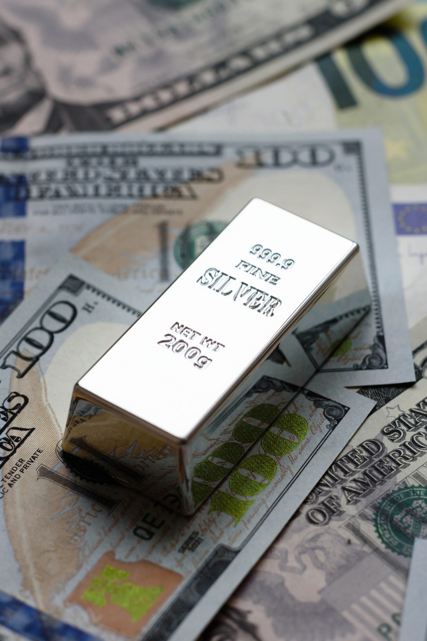 A silver bar, white metal against a backdrop of money, as a concept for the sales market. A silver bar as a background for your design