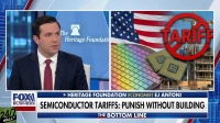 A split-screen view features economist EJ Antoni on the left, wearing a suit and red tie against a blue background with 'The Heritage Foundation' logo. The right side displays a composite graphic with an American flag, a colorful silicon wafer, two computer chips, and a construction site, overlaid by a large red prohibition symbol with the word 'TARIFF'. A lower third banner reads 'SEMICONDUCTOR TARIFFS: PUNISH WITHOUT BUILDING' with 'FOX BUSINESS' and 'THE BOTTOM LINE' logos.