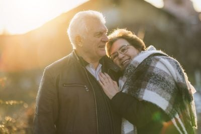 Portrait of a happy senior couple is hugging each other tightly, expressing love and affection.