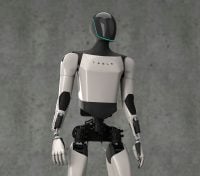A sleek, modern white and black humanoid robot, the Tesla Bot, is shown from the chest up against a textured gray wall. The robot has a glossy black head with a thin, glowing teal line outlining the face area, resembling an inverted U. Its torso is primarily white with 'TESLA' written in black letters across the chest, and its arms are white with black joint accents. The exposed lower torso reveals dark mechanical components. The robot is looking slightly to its right.