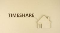 Cardboard home icon with TIMESHARE text on the table