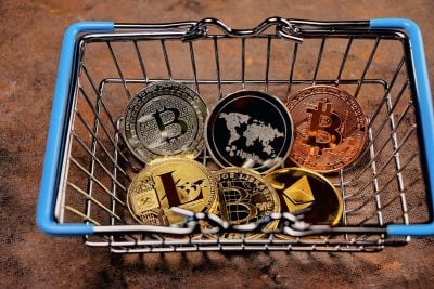 a consumer basket at the bottom of which there are coins of electronic cryptocurrencies Bitcoin, Ethereum, Litecoin, Ripple, as a concept for optat on the Internet