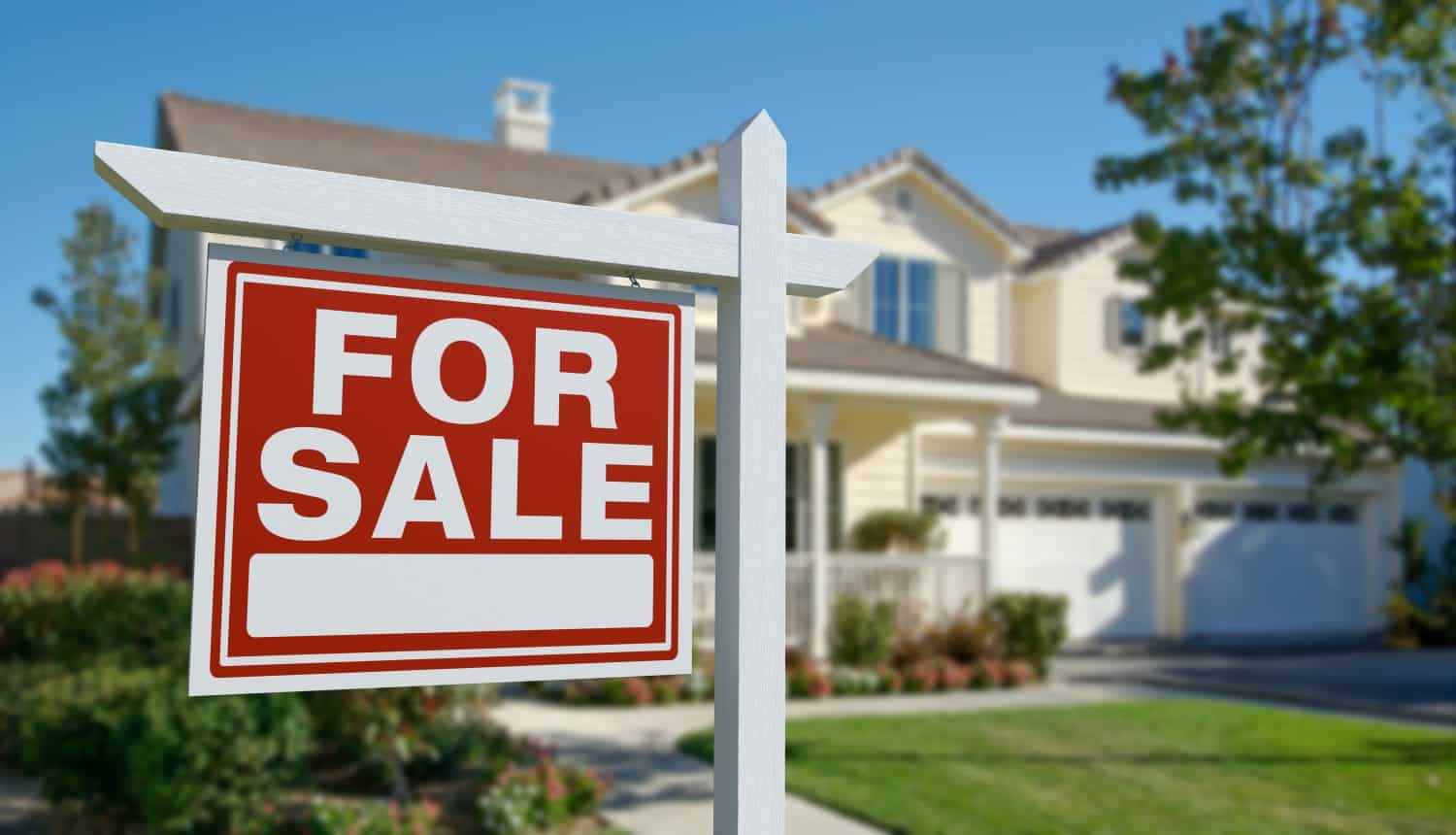 For Sale Real Estate Sign in Front of Beautiful House.