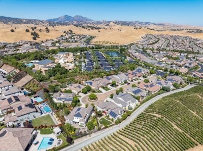 Aerial images over the Trilogy 55+ and older community in Brentwood, California with beautiful homes with solar, surrounded by hills with vineyards and mt.diablo