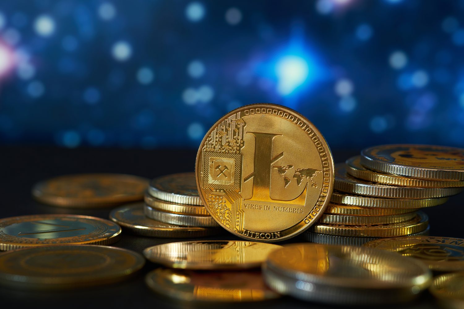 Golden litecoin cryptocurrency and abstract blue graphic background