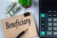 BENEFICIARY - word on a brown sheet on the background of a calculator and banknotes. Business concept