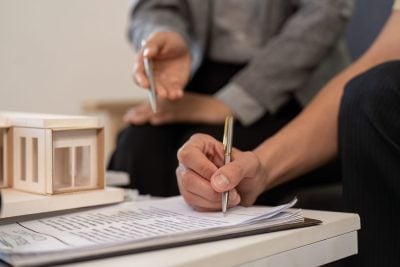 Real estate agent assisting client with paperwork and model home