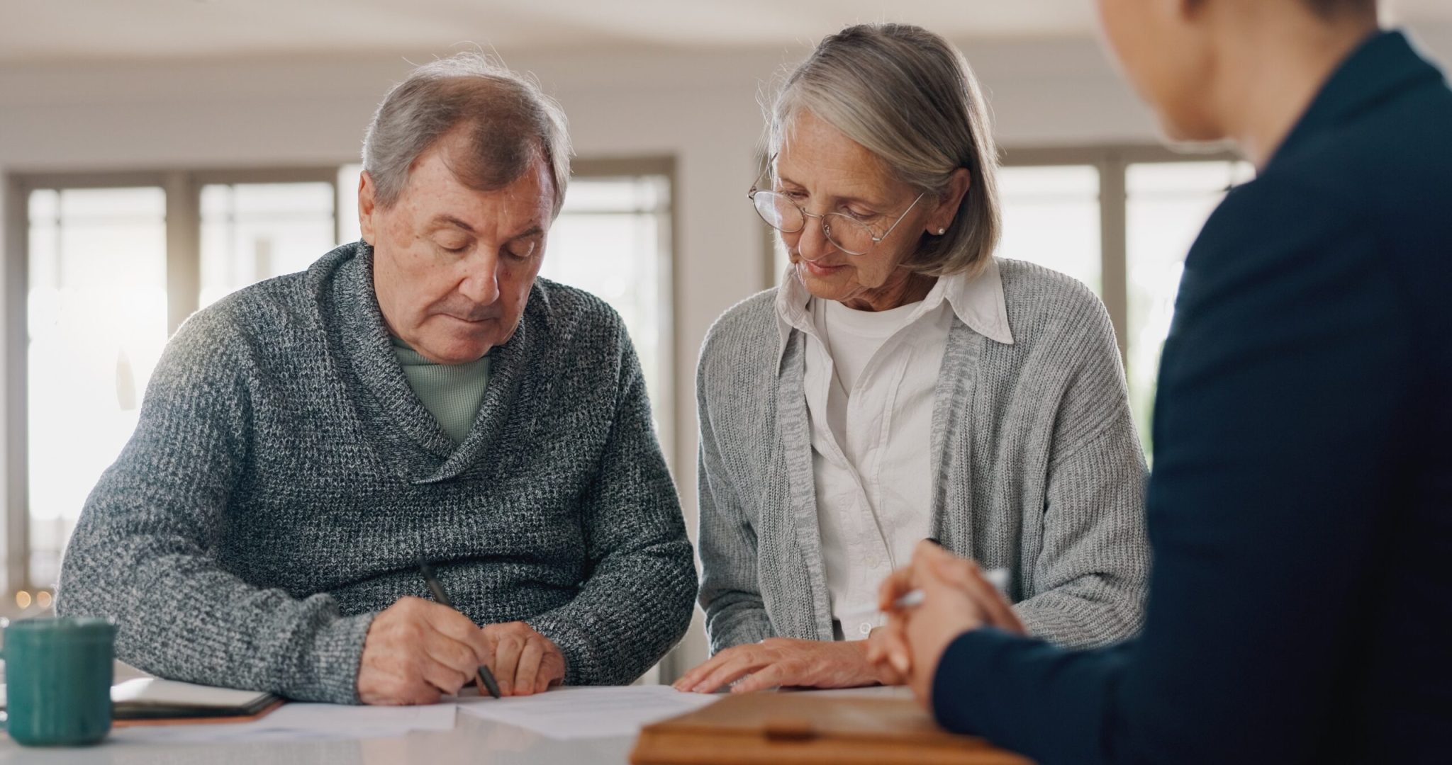 Signature, paperwork and senior couple with financial advisor for retirement annuity saving account. Discussion, finance documents and elderly man and woman wit