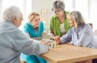 Retirement home activity with skilled nurse, nursing care and service for seniors, happy old people enjoy good time, elder patients under supervising and gerontological guiding, playing game fun
