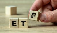 A hand arranging wooden blocks to form the acronym ETF on a light wooden surface. This image illustrates investment concepts, financial education, and stock market strategies.