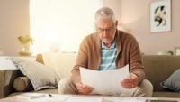 Senior man, reading or finance with documents for retirement or pension fund at home. Elderly, male person or budget planning with paperwork for mortgage expenses, financial bills or invoice at house