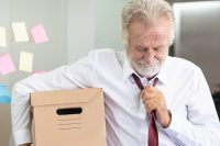 Senior employee carrying stuff box and ready to retired from company.