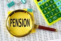 PENSION - word under a magnifying glass on the background of a calculator and a sheet with numbers