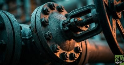 A tightly bolted industrial valve symbolizes the 'Hold' consensus and the pressure of peak valuation, using a dramatic Dutch angle to create a sense of tension that demands attention.