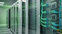 A high-tech server room with rows of data racks illuminated by green lights and organized blue fiber optic cabling.