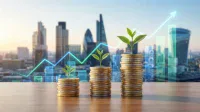 Three increasing stacks of gold and silver coins, each with a small green plant growing from the top, are arranged on a wooden surface. In the blurred background, a modern cityscape with tall skyscrapers is visible under a bright sky. Overlaying the cityscape is a vibrant blue and green line graph trending sharply upwards with an arrow, along with semi-transparent vertical bar chart elements, symbolizing financial growth.