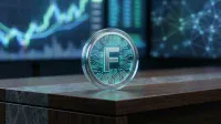 A close-up of a silver-rimmed digital coin with a glowing blue circuit board design and a metallic letter 'F' at its center. The coin sits on a dark wooden and gray marbled desk, with blurred blue screens displaying financial graphs and a connected network in the background.