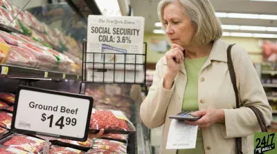 A senior woman with gray hair, wearing a beige jacket and green shirt, stands in a supermarket meat aisle. She holds a calculator and a grocery list in her left hand, and a package of ground beef in her right, looking down thoughtfully. A price sign in the foreground displays 'Ground Beef $14.99'. In the background, a newspaper rack shows a headline 'SOCIAL SECURITY COLA: 3.6%'.