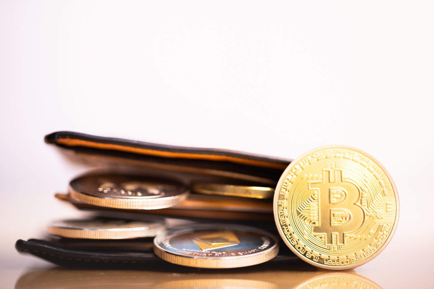 Bags with cryptocurrencies golden bitcoin, in a black wallet. Bags with bitcoin. Cryptocurrency hardware wallet concept.