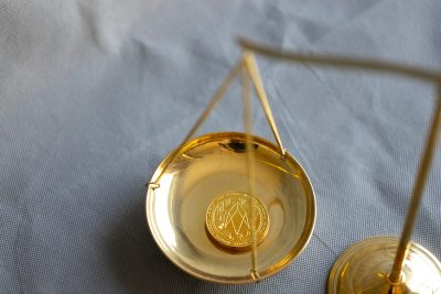 EOS cryptocurrency coin on judge balance scales. Disputes connected with EOS cryptocurrency concept.