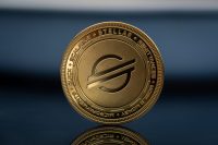 Stellar XLM Lumens Cryptocurrency physical coin placed on the reflective blue surface