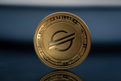 Stellar XLM Lumens Cryptocurrency physical coin placed on the reflective blue surface