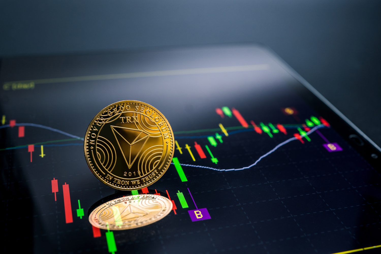 TRON currency with blockchain concept on laptop and charts and graphs.