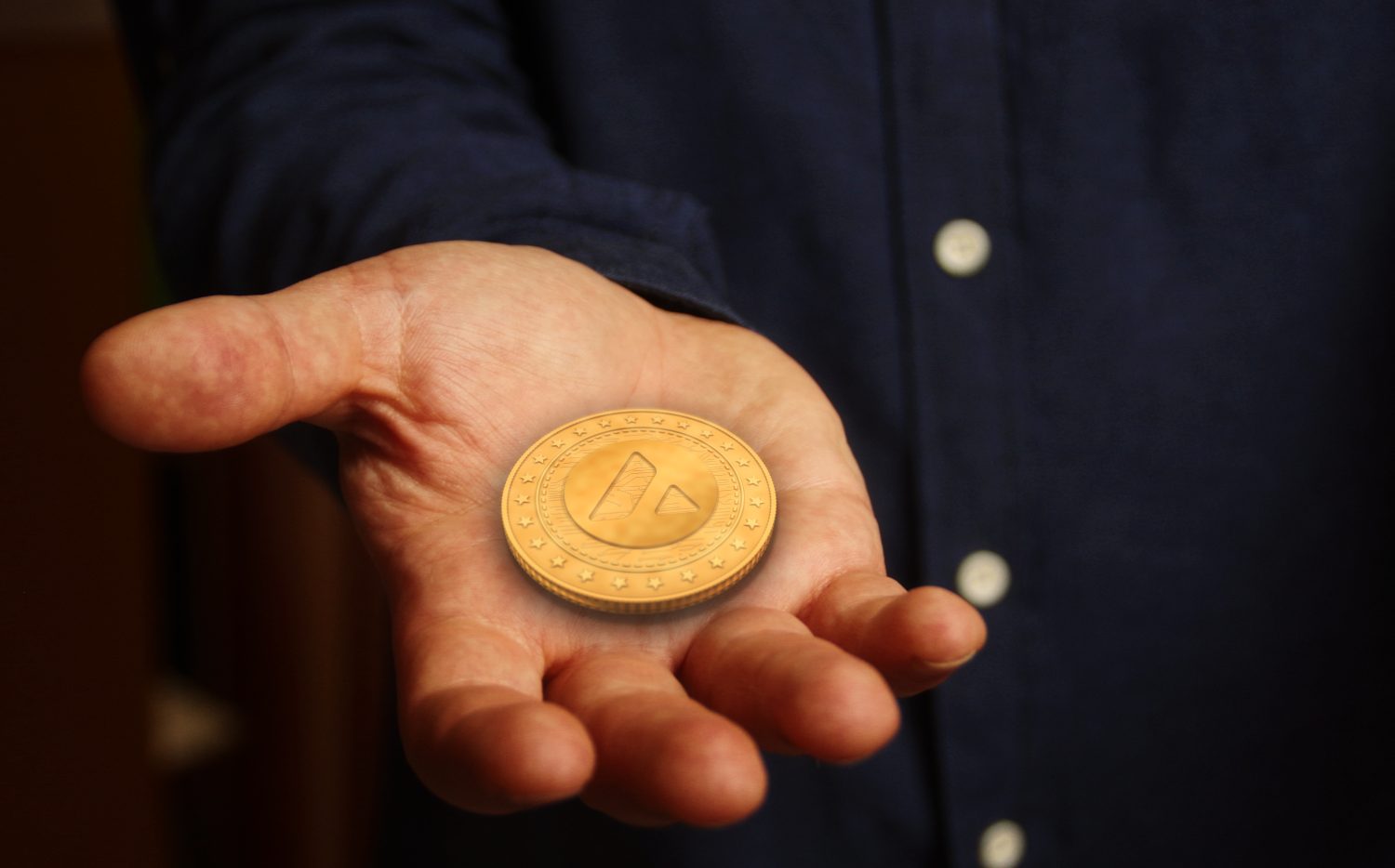 Avalanche AVAX cryptocurrency symbol golden coin in hand abstract concept.