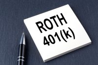 ROTH 401K text on sticker with pen on the black background