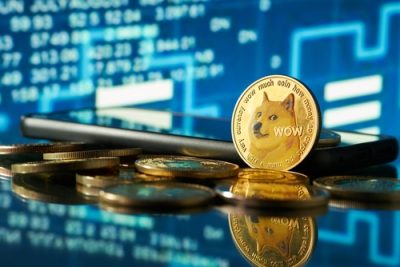 Close-up of dogecoin cryptocurrency with blurred background of stock charts in blue color