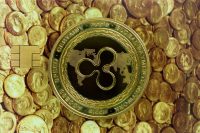 Cryptocurrency concept. A close up shot of Ripple XRP cryptocurrency coin on top of a credit card with a picture of ancient gold coins. selective focus in the center.