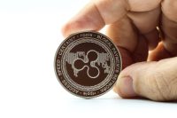 Hand holding a cryptocurrency of Ripple XRP. Space for text.