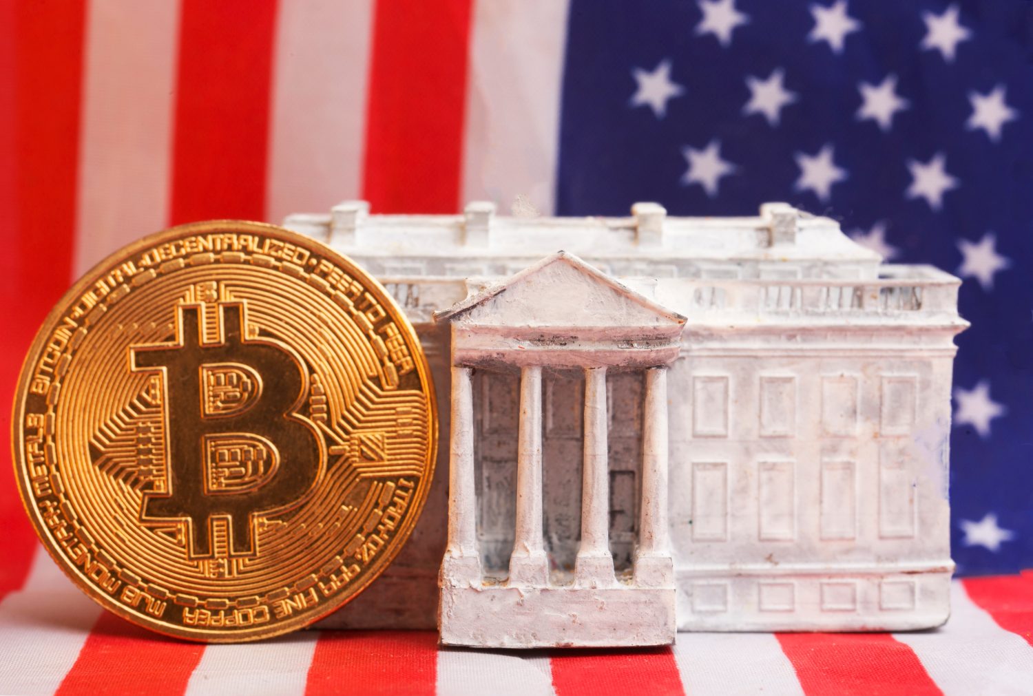 The White House and the Bitcoin cryptocurrency against the backdrop of the US flag.