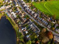 High angle view of suburban homes, gardens, and autumn trees in a Welsh valleys town.