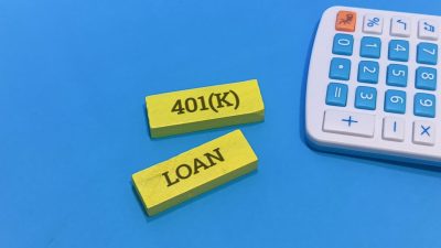 Financial concept showing yellow blocks labeled 401k and loan beside a white and blue calculator against a bright blue background illustrating the decision-making process for retirement fund borrowing.