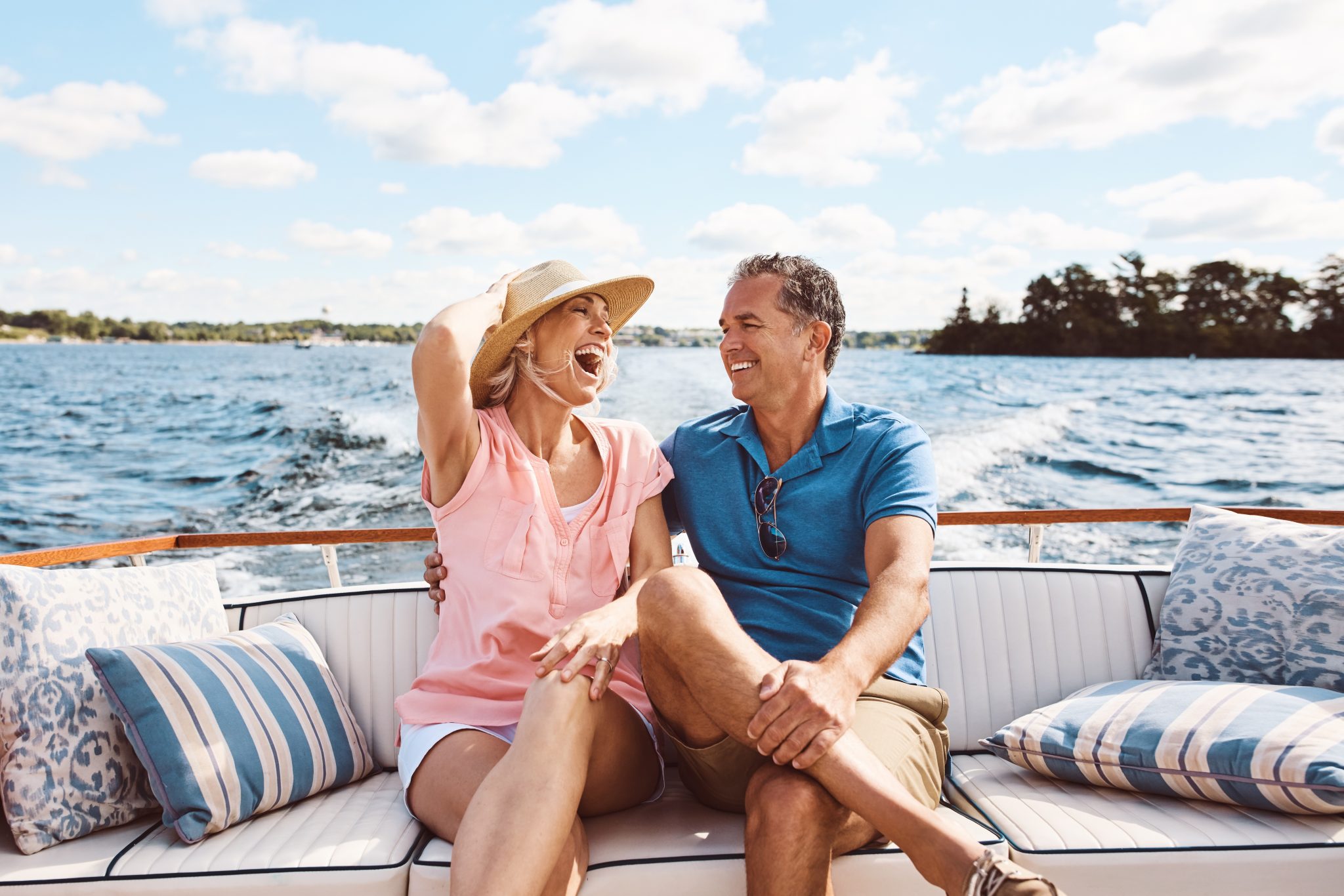 Laughing, happy couple and on a boat for retirement travel, summer freedom and holiday in Bali. Smile, love and a senior man and woman on a yacht for vacation a