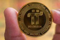 Cryptocurrency concept. two male fingers holding a shiny Pi Network cryptocurrency coin in front of a blurred background. selective focus