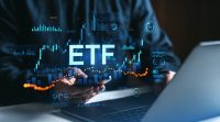 Person using smartphone and laptop with ETF data, stock charts, and analytics on digital interface, financial market investment concept