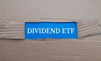 Dividend ETF text on blue paper over torn card box background