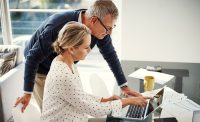 Mature couple, laptop and talking with point for financial planning, investment or budget for retirement. Man, woman and tech with paperwork for online banking, account or tax savings in home