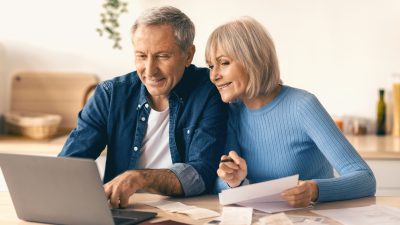 Older Couple Working Together on Finances at Home in a Kitchen Setting