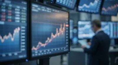 A blurred image of a financial trading room with multiple monitors displaying blue and orange line graphs, some showing upward trends, and financial data tables. In the foreground, a large monitor clearly shows an orange line graph on a blue grid background, trending upwards. A man in a suit, seen from behind and out of focus, stands in the middle-right, holding a tablet and observing the screens.