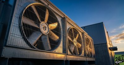 The sheer scale of industrial cooling systems represents the massive physical footprint of data centers. Using a low-angle shot during golden hour creates a 'prestige' look that aligns with high-level corporate reporting while emphasizing the massive scale of construction.